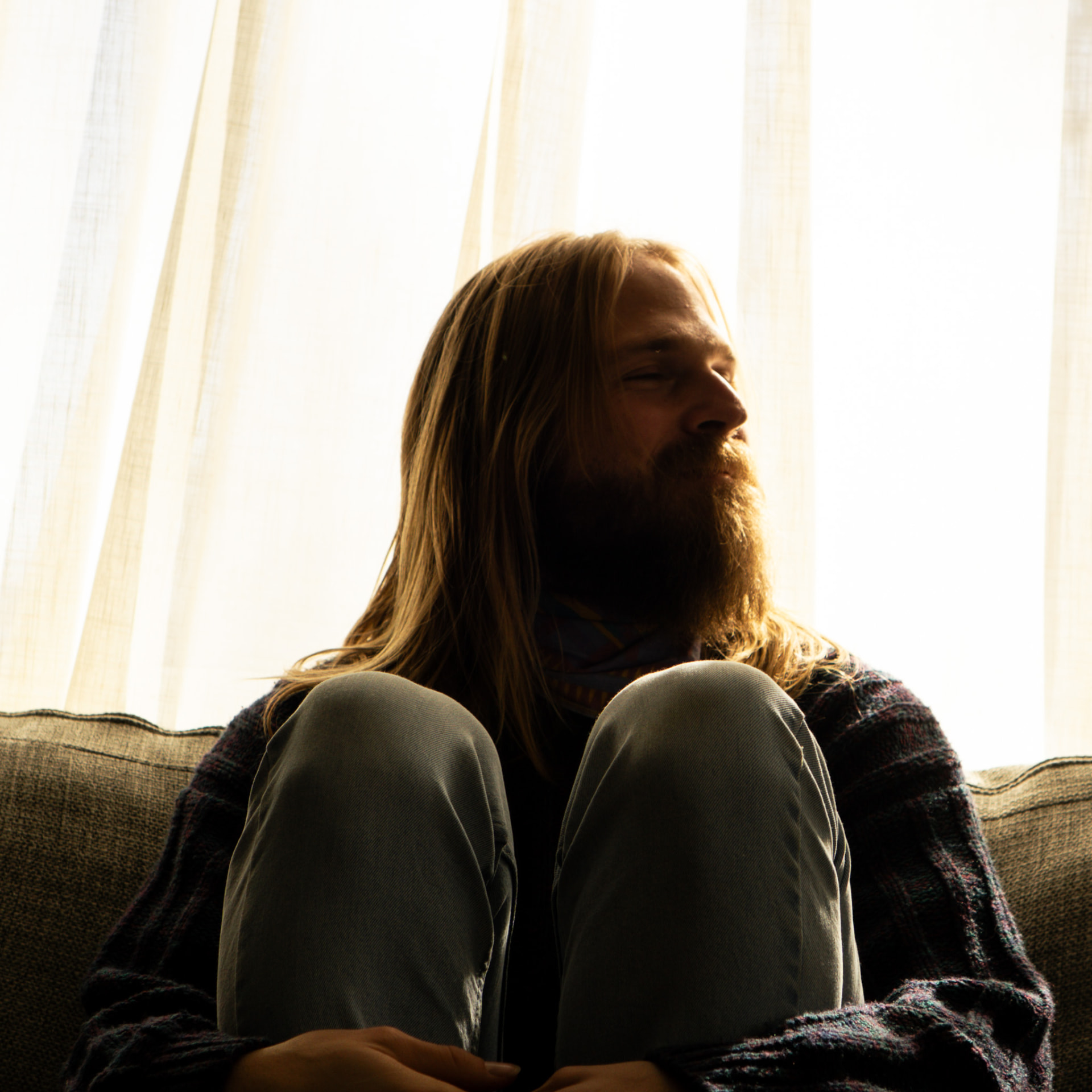 Backlit couch portrait through sheer curtains