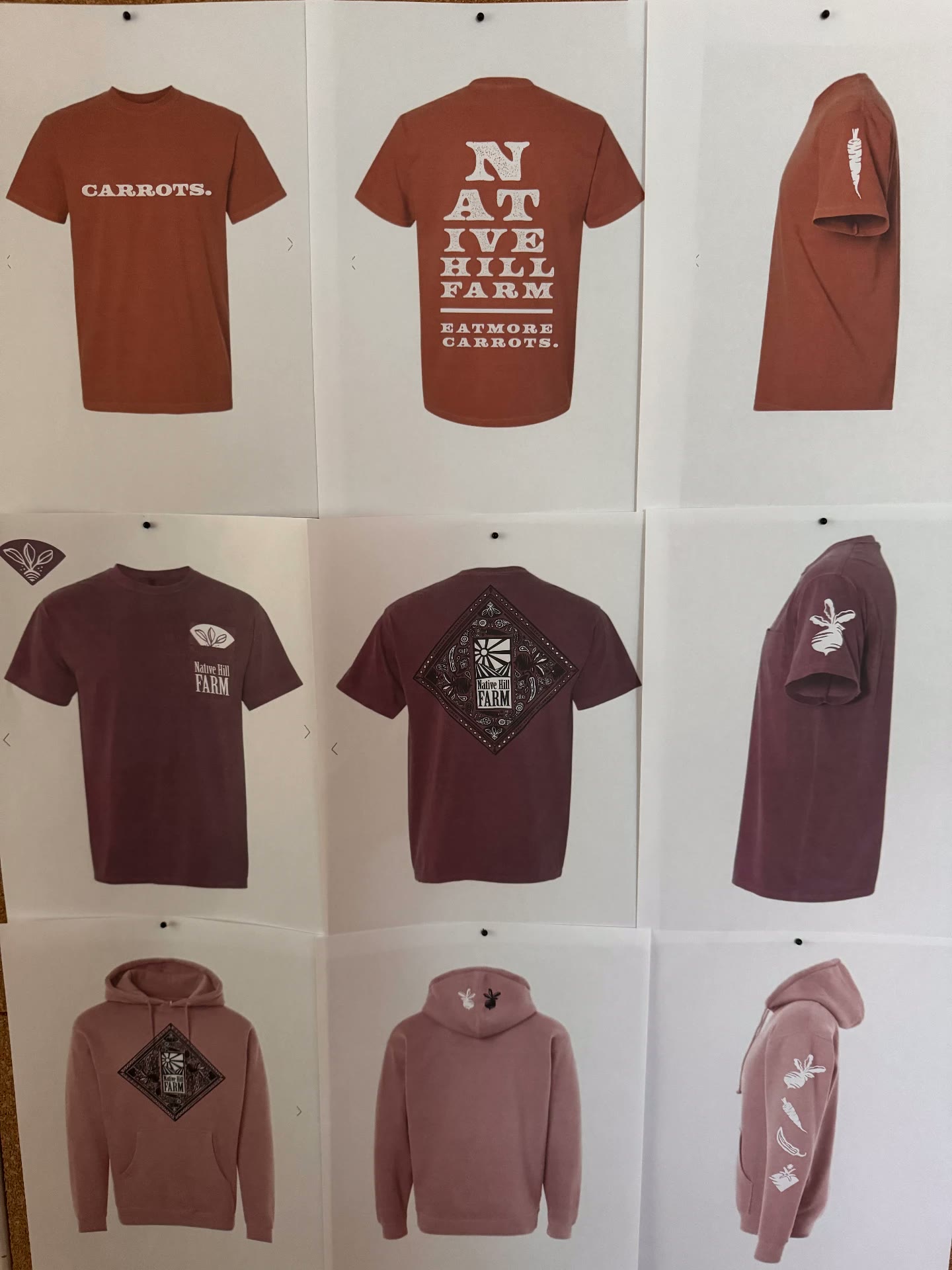 Printed concept boards pinned to a corkboard showing tee and hoodie designs